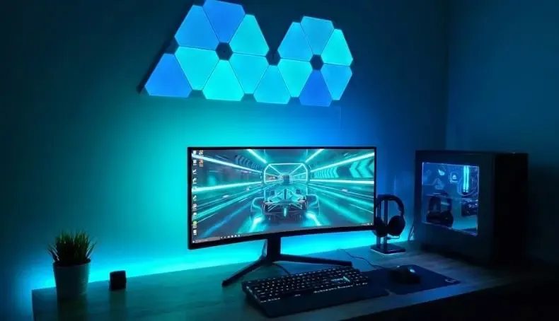 Setup gaming con monitor, tiras LED Govee traseras y paneles hexagonales en la pared sincronizados en color morado